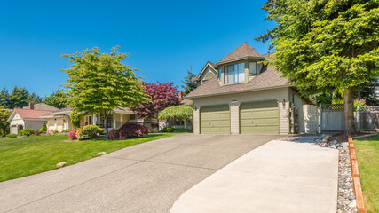 Two story stucco luxury house with nice summer  landscape in Vancouver, Canada, North America. Day time on June 2024.