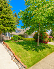 Obraz premium Two story stucco luxury house with nice summer landscape in Vancouver, Canada, North America. Day time on June 2024.
