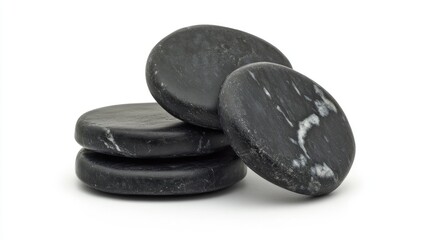 Fototapeta premium Stacked black massage stones arranged on a white background for relaxation and wellness therapy concepts
