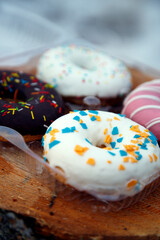 A selection of freshly baked donuts in multi-colored glaze. Beautiful sweet donuts with sprinkles. Dessert close-up. 