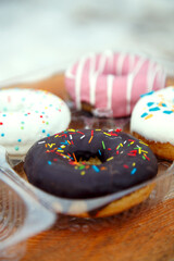 A selection of freshly baked donuts in multi-colored glaze. Beautiful sweet donuts with sprinkles. Dessert close-up. 