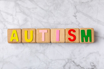 Autism awareness day.2 April world autism awareness day background.Design element.Care Awareness campaign for Autism.AUTISM text with colorful wooden puzzles, letters and cubes.Space for text.Top view