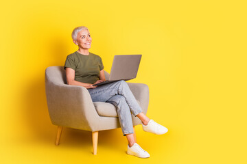 Full length photo of cheerful pretty lady dressed khaki t-shirt working modern gadget looking empty...