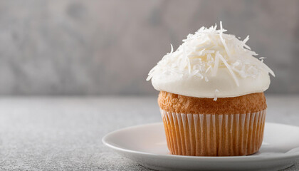 Tasty coconut cupcake on ceramic plate. Sweet food. Delicious treat.
