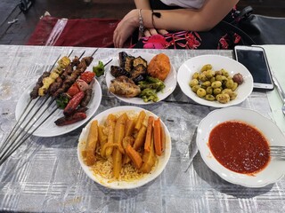Grilled Skewers and Sides on Outdoor Dining Table in Jemaa el-Fnaa, Marrakech