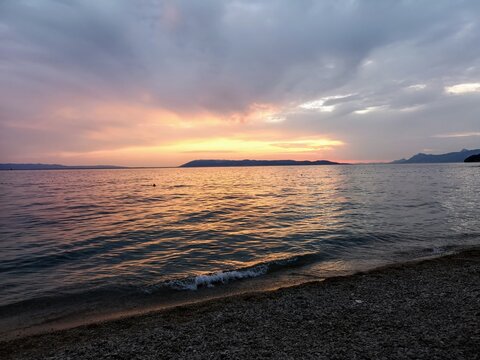 Beach Sunset Over Serene Waters With Vibrant Sky