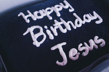 Purple yam cake with "Happy Birthday Jesus" text lettering design during Merry Christmas day party. Selective focus. Isolated. Closeup.
