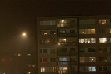 A tall building that features numerous windows is beautifully illuminated during the night,...