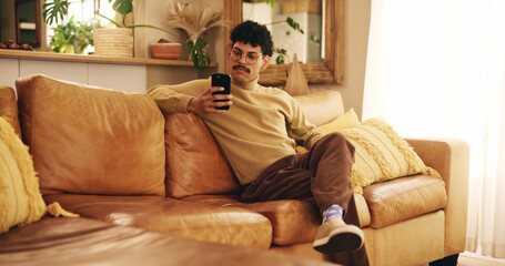 Man, phone and texting on sofa, relax and reading in living room, chat and mobile app in home....