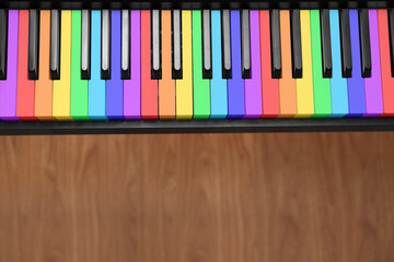 Obraz premium Piano with keys in colors of rainbow on floor, top view. Musical instrument