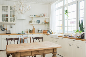 Empty white wooden kitchen interior with dining room. Scandinavian classic minimalistic bright kitchen with white and wooden details. Modern white kitchen clean contemporary style interior design