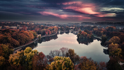 ​Aerial drone view of Zalew Nowohucki lake in Krakow during autumn sunset with vibrant pink sky © DRONE QUEST