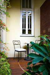 White vintage chairs and a small table stand by the window on the threshold, creating a cozy, calm atmosphere where light and silence fill the space with a feeling of homely warmth.