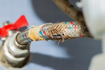 water hose to the mixer with a cracked and rusty braid. replacement is necessary. close-up