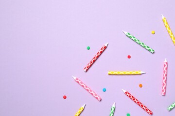 Multi-colored holiday candles on color background, flat lay. Birthday concept 