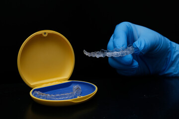 Orthodontic treatment with clear aligners used by dental professionals to realign teeth. Restoration of teeth with clear aligner trays. Orthodontic specialty. © UniqDream