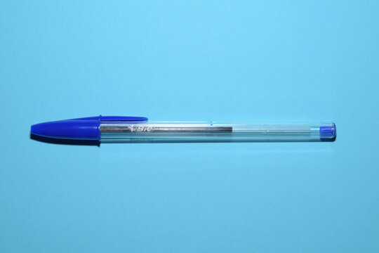 Un boligrafo BIC azul y una cartulina azul de fondo. 