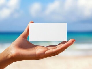 Woman hand holding a blank card on a beach in a hot summer day.