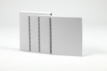 Set of closed spiral bound books in front of sleeve. Case of notebooks isolated on white background