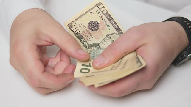 Closeup of hands counting five dollar bills, showcasing financial transactions and cash handling in various settings