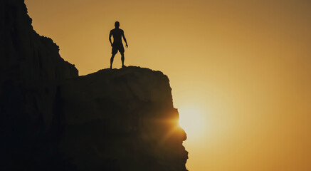 Silhouette of athlete standing on cliff after succesful climbing UP during sunset. Warm light outlines figure creating dramatic scene representing goals effort and personal achievement
