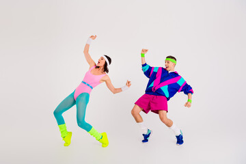 Energetic couple dancing in colorful retro exercise outfits in a cheerful pose, capturing the essence of vintage aerobics style