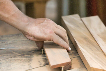 A man is working on a piece of wood with a saw