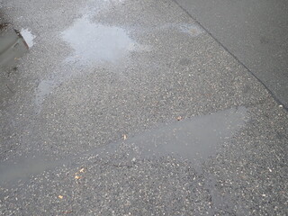 asphalt road with broken cracks after rain