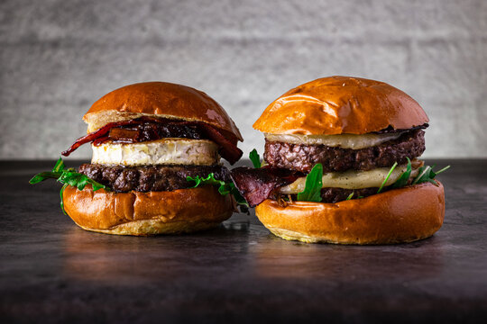 Delicious gourmet burgers with brie, bacon, and arugula on buns