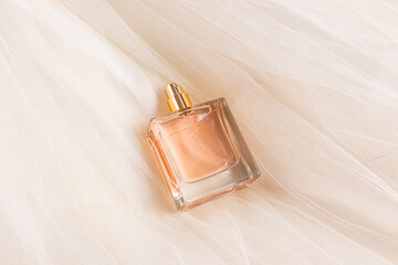 Elegant square perfume bottle resting on soft fabric background