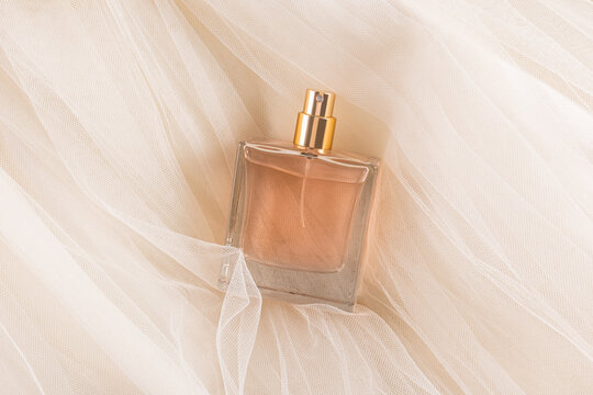 Elegant square perfume bottle on sheer fabric background