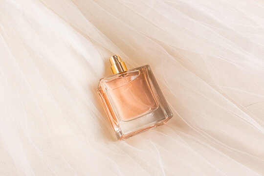 Elegant square perfume bottle resting on soft fabric background