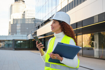Latin female engineer with curly hair in urban setting