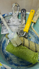 A bowl full of paint brushes and rollers