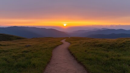 Beautiful landscape of a mountain range at sunset. the sky is a gradient of orange, pink, and purple, with the sun setting in the distance.