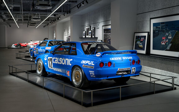 FUJI, JAPAN - 23 NOVEMBER 2024: ON DISLPAY AT THE FUJI SPEEDWAY MOTOR MUSEUM, VINTAGE MOTORSPORT ICON, THE CALSONIC NISSAN SKYLINE R32 GT-R, REAR VIEW OF CAR WITH OTHER DISPLAY VEHICLES IN BOKEH