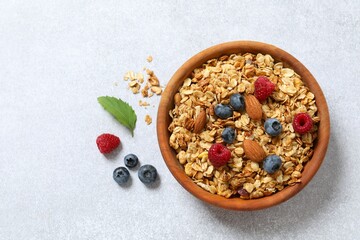 Delicious granola with berries and yogurt on a light background