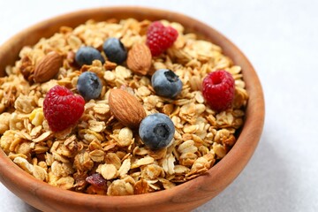 Delicious granola with berries and yogurt on a light background
