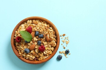Delicious granola with berries and yogurt on a light background