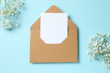 Top view photo with paper envelope and gypsophila flowers on color background 