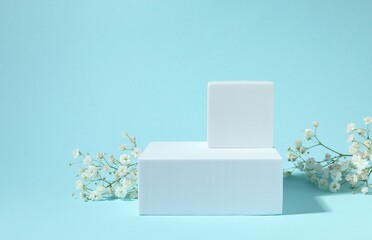 Podium and white gypsophila flowers on color background