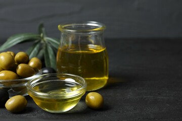 Bowl of fresh olive oil and olives with leaves on the table