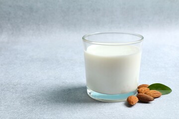 Glass of almond milk on gary background