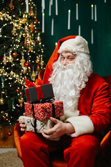 Santa Claus sitting in a cozy chair, holding several gifts and winking at the camera, eagerly awaiting to give them to children.