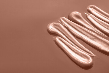 Demonstrating color of the year 2025. Mocha mousse color swatch. Creative cosmetic brushstrokes isolated on a brown background. Paint texture banner with copy space.