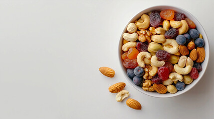 A bowl of mixed nuts and dried fruits, styled on a plain white background