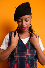 Portrait of beautiful brunette teenage girl wearing black beret with braids in her hair, smiling and happy posing for photo.