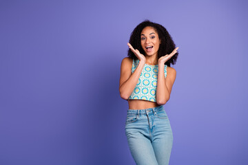 Charming young woman in stylish summer top, expressing joy against a vivid violet backdrop. Ideal for fashion, lifestyle