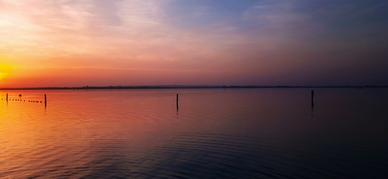 Abendstimmung am D&uuml;mmer See mit roten Wolken vor blauem Himmel 
