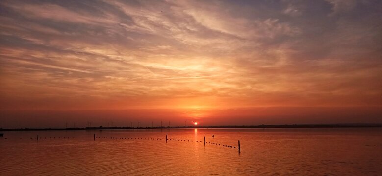 Die Sonne versinkt am D&uuml;mmer See mit sch&ouml;nem Abendrot 
